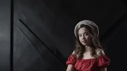 Pakai baret berwarna khaki yang dipadukan dengan atasan off shoulder merah marun, gaya Lyodra berkesan aura feminin. (Liputan6.com/IG/@lyodraofficial)