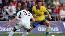 Pemain Arsenal Mesut Ozil dihadang Pemain Swansea City Ben Davies Pada pertandingan Liga Premier Inggris antara Swansea City dan Arsenal di Stadion Liberty di Swansea (28/09/13). (AFP/Paul Ellis)