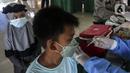Seorang anak menerima vaksin booster COVID-19 di Taman Pemuda Pratama, Depok, Jawa Barat, Kamis (7/4/2022). Bagi warga yang belum vaksin atau vaksin baru sekali tetap harus tes PCR. (Liputan6.com/Johan Tallo)