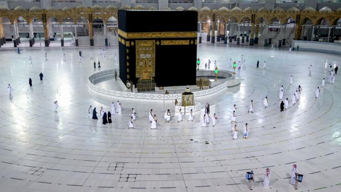 Warga Saudi dan warga asing mengelilingi Ka'bah (tawaf) saat melaksanakan umrah di kompleks Masjidil Haram, kota suci Makkah, Minggu (4/10/2020). Pemerintah Arab Saudi mengizinkan umrah kembali mulai Minggu (4/10) setelah sekitar tujuh bulan ditangguhkan karena pandemi COVID-19. (AFP)