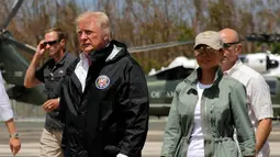 Presiden AS Donald Trump dan ibu negara Melania Trump setibanya di Luis Muniz Air National Guard Base, Puerto Rico, Selasa (3/10). Trump datang untuk melihat langsung kehancuran akibat terjangan badai Maria di Puerto Rico dua pekan lalu. (AP/Evan Vucci)