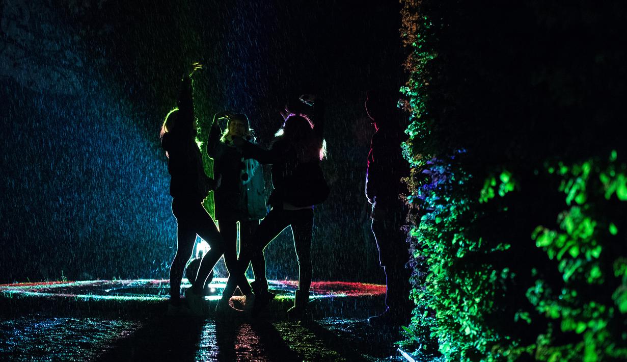 Siluet Sejumlah pengunjung saat berada di dekat seni instalasi cahaya "Painting the Night" karya seniman Austria Victoria Coeln saat hujan turun di taman Heruerhae Gaerten di Hanover, Jerman utara, (4/5). (AFP Photo/dpa/Silas Stein/Jerman Out)