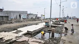 Anak-anak saat bermain di bekas lokasi warung makan pasca direlokasi di Pelabuhan Kali Adem, Muara Angke, Jakarta Utara, Senin (13/6/2022). Pengelola Pelabuhan Kali Adem merelokasi sebanyak 56 pedagang yang sebelumnya menempati dermaga ke lokasi baru. (merdeka.com/Iqbal S Nugroho)