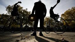 Para penggemar mengenakan pakaian bersejarah mengendarai sepeda yang mereka sebut penny-farthing, atau yang juga dikenal sebagai high wheel, dalam kompetisi tradisional 'One Mile Race' di Taman Letna, Praha, Republik Ceko, pada 1 November 2025. Para peserta lomba bersaing untuk menjadi yang tercepat atau menjadi lambat dan menjaga keseimbangan. (Michal Cizek/AFP)