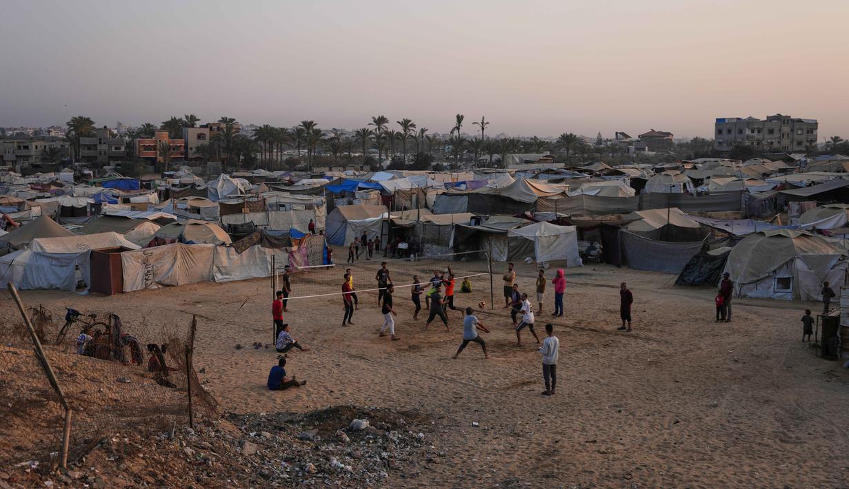 Anak-anak muda Palestina bermain voli di kamp tenda pengungsian di Zawayda, Jalur Gaza tengah, Selasa, 4 November 2025. Selasa 4 November 2025. Aktivitas ini memberikan momen singkat untuk beristirahat dan mencari kegembiraan di tengah kondisi sulit dan tantangan berat yang dihadapi para pengungsi di daerah tersebut. (AP Photo/Abdel Kareem Hana)
