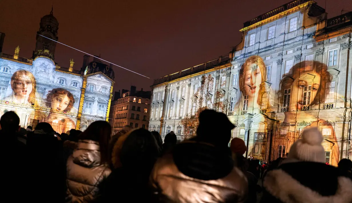 Orang-orang menghadiri pertunjukan cahaya malam di Lyon, Prancis, 8 Desember 2022. Jutaan orang diperkirakan akan menyaksikan acara Festival Cahaya selama empat hari di kota tersebut. (AP Photo/Laurent Cipriani)