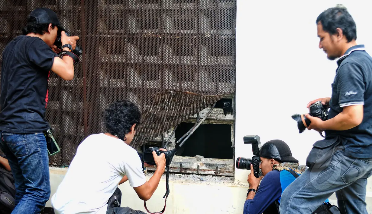 Pewarta foto sedang mengambil foto kondisi tembok ruang tahanan BNN yang dijebol tahanan, Jakarta, Selasa (31/3/2015). Tembok ruang tahanan BNN berukuran 16 milimeter, luas jebolan 30 sentimeter (cm) dengan lebar 40 cm. (Liputan6.com/Yoppy Renato)