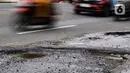 Sejumlah pengendara kendaraan bermotor melewati salah satu titik kerusakan di Jalan Raya Parung-Ciputat Kota Depok, Jawa Barat, Senin (10/2/2025). (Magang/Liputan6.com/Muhammad Rizal)