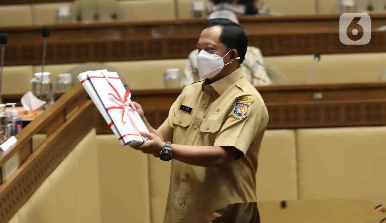 Mendagri Tito Karnavian menyerahkan DIM saat rapat kerja di Kompleks Parlemen MPR/DPR-DPD, Senayan, Jakarta, Selasa (21/6/2022). Rapat juga membahas Pengantar/Pandangan Pemerintah dan DPD RI terhadap RUU tentang 3 RUU Pembentukan Provinsi tersebut. (Liputan6.com/Angga Yuniar)
