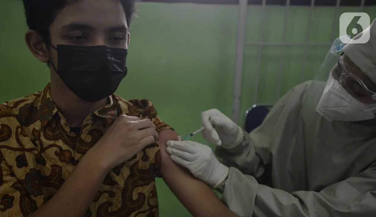 Seorang siswa menjalani vaksin COVID-19 di SMUN 20 Jakarta, Kamis (1/7/2021). Per tanggal 1 Juli 2021, anak-anak usia 12-17 tahun di DKI Jakarta sudah mulai mendapatkan vaksinasi. Agar anak-anak kita terlindungi dari wabah Covid-19 dengan varian baru. (merdeka.com/Imam Buhori)