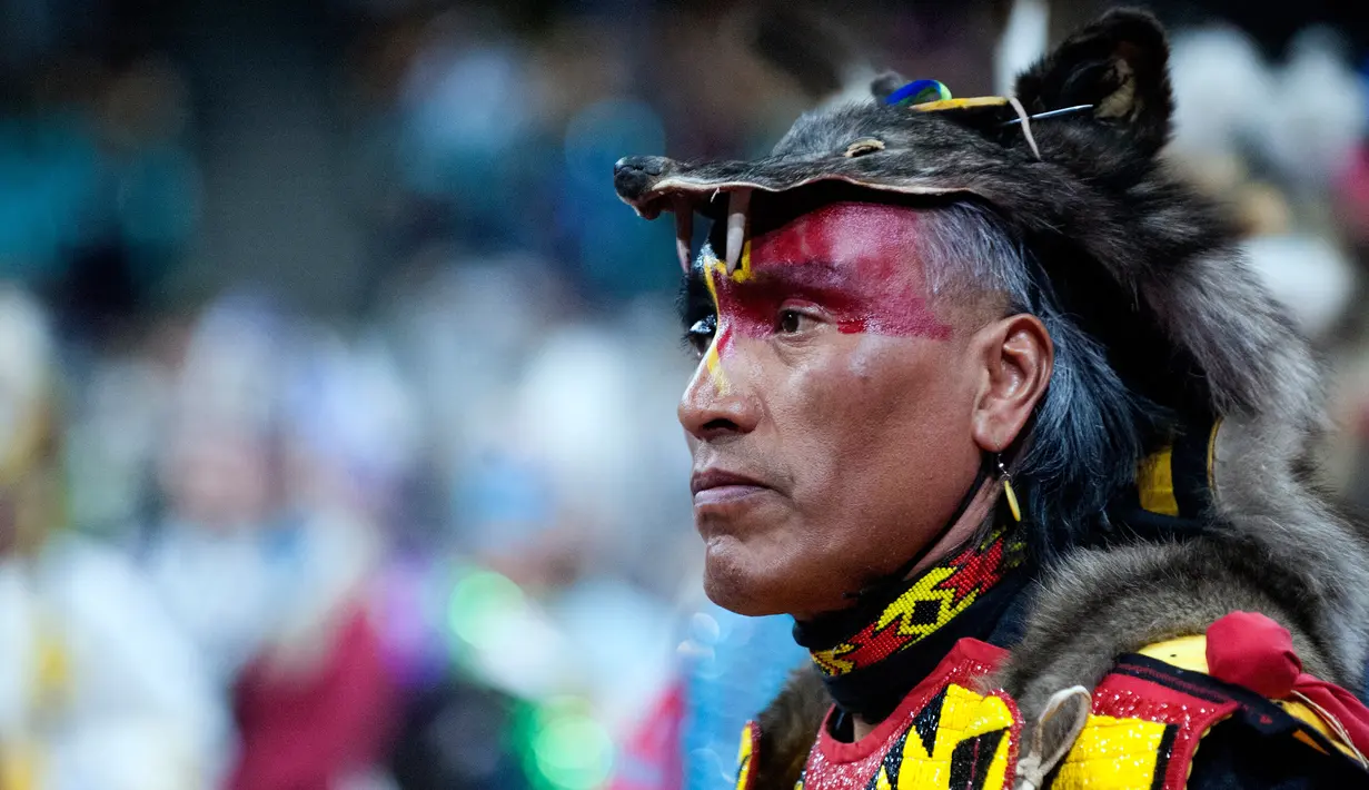 Penari dari Nakoda Nation of Saskatchewan, Kevin Haywahe saat mengikuti Grand Entry of the Denver March Powwow di Denver, Colorado (24/3). Para penari mewakili suku-suku dari seluruh Amerika Serikat dan Kanada. (AFP/Jason Connolly)
