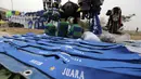 Seorang pedagang atribut merapikan dagangannya di Stadion Si Jalak Harupat, Bandung, Sabtu (24/10/2015). (Bola.com / Nicklas Hanoatubun)