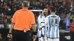 Lionel Messi (tengah) dan Maxi Rodriguez (kanan) saat bertanding memakai seragam Timnas Argentina dalam acara pertandingan perpisahan Maxi Rodriguez sebagai pesepak bola profesional yang diselenggarakan di Marcelo Bielsa Stadium, Argentina, Minggu (25/6/2023). (AFP/Stringer)