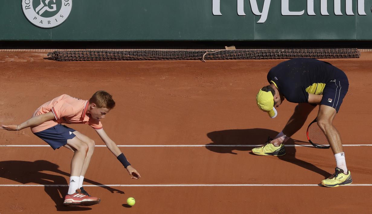 Seorang ball boy mengambil bola saat petenis Serbia, Dusan Lajovic gagal mengembalikan bola ke arah petenis Jerman, Alexander Zverev pada ajang Prancis Terbuka 2018 di Roland Garros stadium, Paris, France, (30/5/2018). (AP/Alessandra Tarantino)