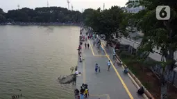 Foto udara memperlihatkan aktivitas warga di pedestrian Danau Sunter, Jakarta, Sabtu (27/6/2020). Beragam aktivitas dilakukan warga sambil menikmati waktu sore di area Danau Sunter, Jakarta. (Liputan6.com/Helmi Fithriansyah)