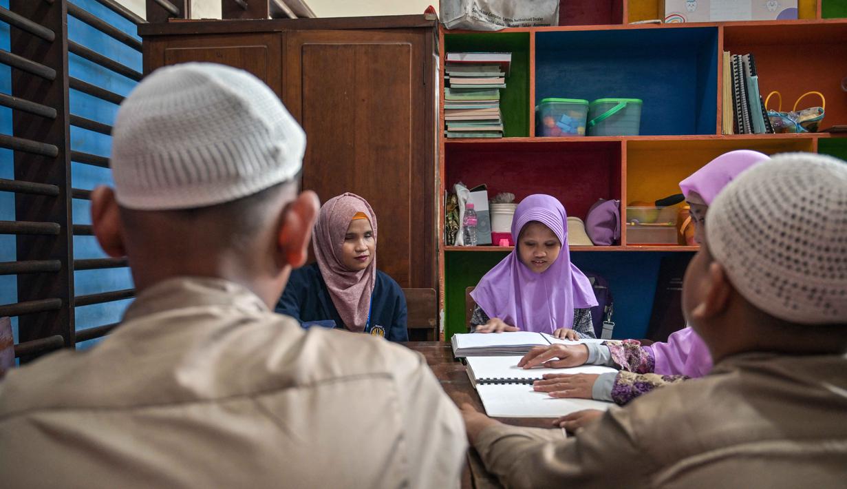 Di sebuah sekolah, sejumlah siswa berkebutuhan khusus netra antusias mengikuti kegiatan membaca Al-Quran dalam huruf Braille selama bulan suci Ramadan 1447 Hijriah. Tampak dalam foto, para siswa tunanetra membaca Al-Quran dalam huruf Braille selama bulan suci Ramadan 1447 Hijriah di sebuah sekolah di Surabaya, Jawa Timur, pada 27 Februari 2026. (JUNI KRISWANTO/AFP)