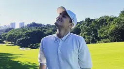 Ia pun tampak santai memakai kaos putih saat bermain golf. Dirinya pun hanya memadukan penampilannya dengan topi serta sarung tangan senada. (Liputan6.com/IG/@k.kbeom)