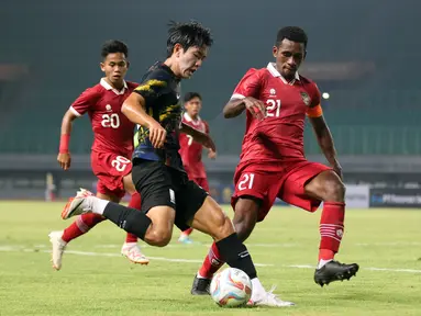 Pemain&nbsp;Indonesia U-17, Iqbal Gwijangge (kanan), berusaha menghadang pergerakan dari pemain Timnas Korea Selatan U-17 dalam pertandingan uji coba yang berlangsung di Stadion Patriot Candrabhaga, Bekasi, Rabu (30/8/2023). (Bola.com/Abdul Aziz)
