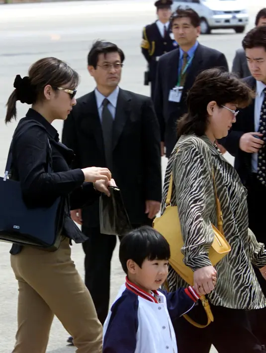 Kim Jong-Nam kecil berjalan dengan dua orang wanita menuju pesawat ANA905 (All Nippon Airways) di bandara Narita dekat Tokyo, 4 Mei 2001. Kim Jong-Nam merupakan putra pemimpin Korea Utara Kim Jong-Il. (AFP PHOTO / Toshifumi Kitamura)