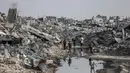PBB memperingatkan bahwa jumlah tersebut masih jauh dari cukup untuk memenuhi kebutuhan mendesak seluruh warga Gaza. Tampak dalam foto, warga Palestina berjalan melalui puing-puing bangunan yang hancur di Jabalia, di bagian utara Jalur Gaza, pada Jumat 7 November 2025. (Omar AL-QATTAA/AFP)