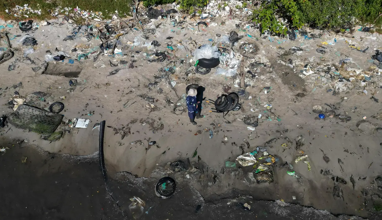 Mereka menyusuri pantai Pulau Pombeba, Teluk Guanabara, Rio de Janeiro, Brasil.untuk mengumpulkan sampah. (Pablo PORCIUNCULA/AFP)