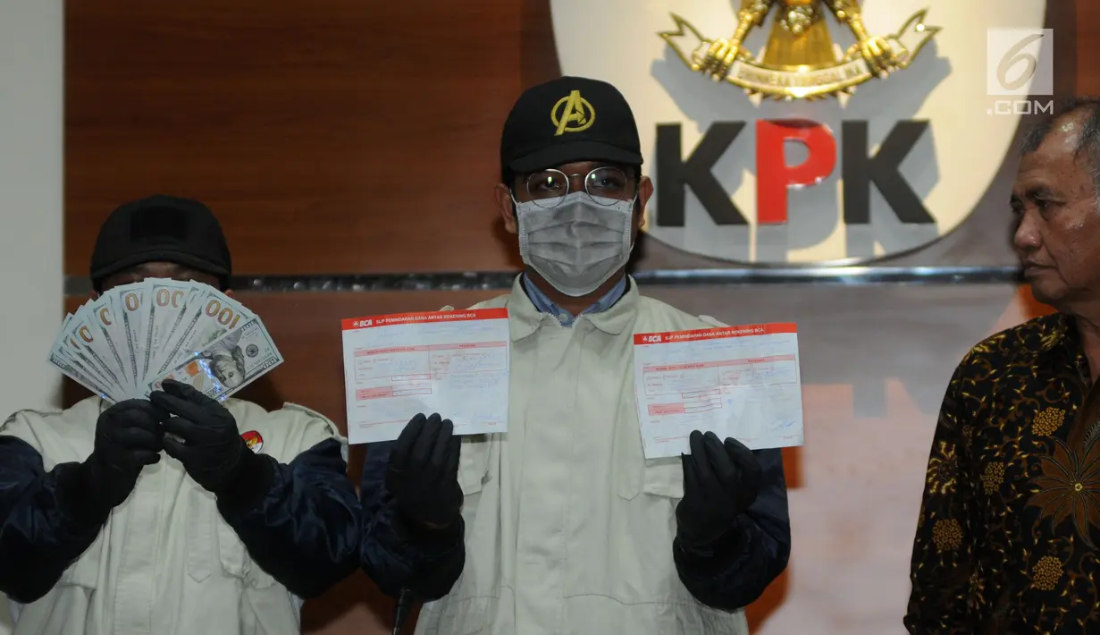 Pimpinan KPK Agus Rahardjo (kanan) mendampingi petugas menunjukkan barang bukti kasus dugaan suap pengurusan izin impor bawang putih tahun 2019 di Gedung KPK, Jakarta, Kamis (8/8/2019). Salah seorang tersangka dalam kasus ini adalah anggota DPR Komisi VI I Nyoman Dhamantra. (merdeka.com/Dwi Narwoko)