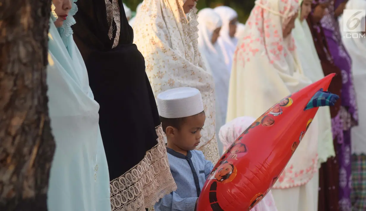 Seorang anak saat salat Idul Fitri 1439 H di lapangan Pancasila, Simpanglima, Kota Semarang, Jumat (15/6). Masyarakat di Indonesia hari ini merayakan Hari Raya Idul Fitri 1439 H sesuai ketetapan pemerintah yakni pada Jumat (15/6). (Liputan6.com/Gholib)