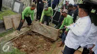 Pekerja membongkar makam fiktif di Tempat Pemakaman Umum (TPU) Menteng Pulo, Jakarta Selatan, Kamis (28/7). 4 makam di bongkar dari total terindikasi 14 makam fiktif yang ditemukan di TPU tersebut. (Liputan6.com/Gempur M Surya)