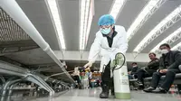 Petugas menyemprotkan cairan disinfektan di Stasiun Kereta Api Yingtan di Nanchang di Provinsi Jiangxi Tengah, China (22/1/2020). Larangan dilakukan untuk mencegah penyebaran virus mematikan tersebut ke wilayah lain maupun ke luar negeri. (AFP Photo/STR)