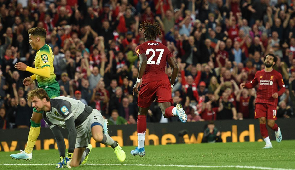 Striker Liverpool, Divock Origi, merayakan gol yang dicetaknya ke gawang Norwich pada laga Premier League di Stadion Anfield, Liverpool, Jumat (9/8). Liverpool menang 4-1 atas Norwich. (AFP/Oli Scarff)