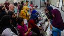 Warga antre untuk menerima bantuan sosial pangan beras saat berlangsung penyaluran di kantor Kelurahan Meruyung, Depok, Sabtu  (11/5/2024). (merdeka.com/Arie Basuki)