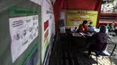 Petugas melayani warga penerima bantuan sosial (Bansos) di kawasan Kedoya Selatan, Jakarta Barat, Rabu (28/7/2021). Pemprov DKI Jakarta sebelumnya menganggarkan Rp 604 miliar untuk program BST bagi warga terdampak pandemi COVID-19. (Liputan6.com/Johan Tallo)
