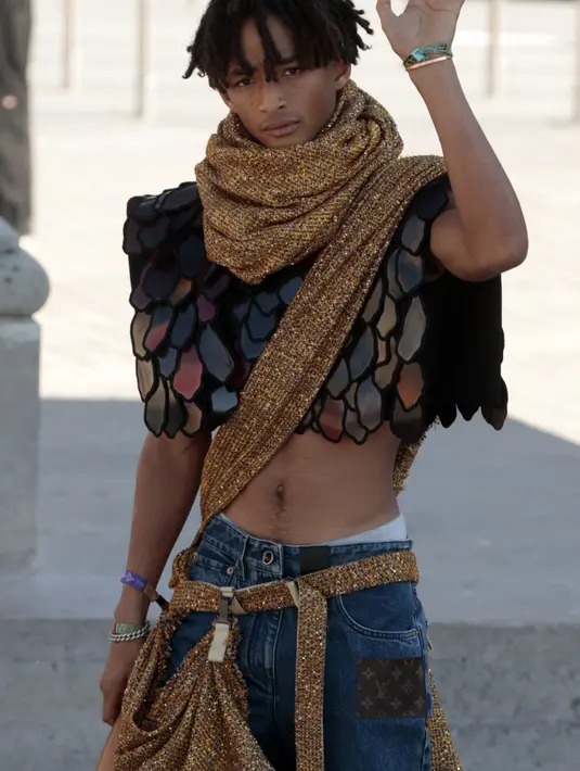 Jaden Smith menyapa penggemarnya saat tiba untuk presentasi koleksi Louis Vuitton Womenswear Sping-Summer 2023 selama Paris Fashion Week, di Paris, pada 4 Oktober 2022. Rapper dan aktor AS ini tampil mengenakan crop top bersisik dan syal tubuh emas melilit tubuhnya. (AFP/GEOFFROY VAN DER HASSELT)