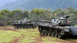 Tentara Taiwan membawa tank saat mengikuti latihan militer di Kabupaten Hualien, Taiwan timur, (30/1). Militer Taiwan memulai latihan gabungan dua hari untuk menunjukkan tekadnya untuk mempertahankan diri dari ancaman China. (AP Photo/Chiang Ying-ying)