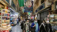 Para pembeli mengenakan masker dan sarung tangan lateks, akibat pandemi coronavirus COVID-19, berjalan di pasar Tajrish selama bulan suci Ramadan di Taheran, Iran (25/4/2020). (AFP/Atta Kenare)