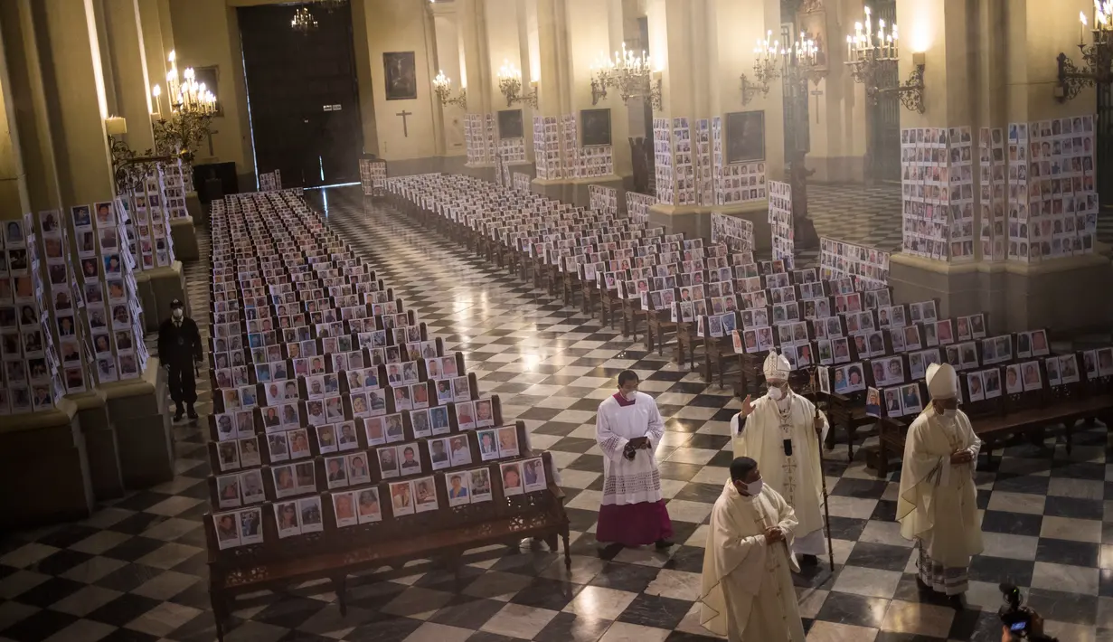 Uskup Agung Lima Carlos Castillo memberkati potret korban meninggal akibat virus corona selama Misa Corpus Christi di Katedral Lima, Minggu (14/6/2020). Misa Minggu di Katedral Lima dihadiri lebih dari 4.000 potret mereka yang telah meninggal dalam pandemi Covid-19 di Peru. (AP Photo/Rodrigo Abd)