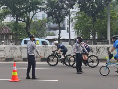 Petugas mengarahakan pesepeda non road bike saat memasuki JLNT Kampung Melayu-Tanah Abang, Jakarta, Minggu (30/5/2021). Dinas Perhubungan DKI Jakarta melakukan uji coba lintasan road bike JLNT Kampung Melayu-Tanah Abang tahap kedua pada pukul 05.00-08.00 WIB. (Liputan6.com/Herman Zakharia)