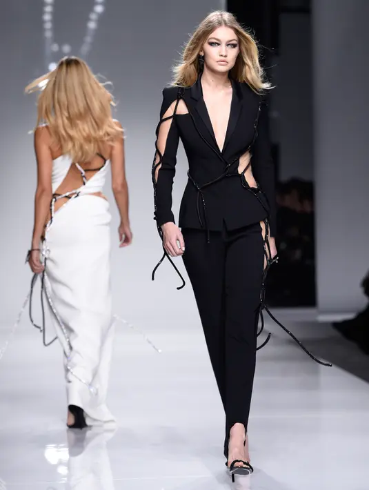 Model asal Amerika Serikat, Gigi Hadid tampil dalam balutan blazer transparan koleksi Atelier Versace pada rangkaian Paris Haute Couture Fashion Week Spring-Summer 2016 di Paris, Minggu (24/1). (AFP PHOTO / Miguel Medina)