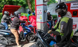 Pertamina Patra Niaga akan mengedepankan keandalan layanan serta kesinambungan distribusi energi nasional. Tampak dalam foto, para pengendara sepeda motor mengantre untuk mengisi bahan bakar sepeda motor mereka di sebuah Stasiun Pengisian Bahan Bakar Umum (SPBU), Jakarta pada Rabu 1 April 2026. (BAY ISMOYO/AFP)