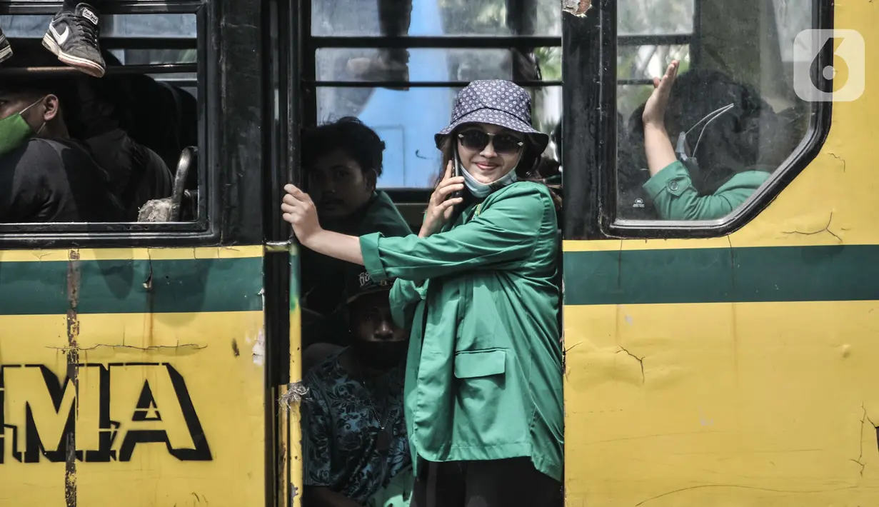 Mahasiswi berada di bus saat mengikuti aksi menolak UU Cipta Kerja di kawasan Patung Kuda, Jakarta, Selasa (20/10/2020). Puluhan mahasiswi turut menghiasi aksi menolak UU Cipta Kerja yang diikuti oleh buruh, mahasiswa, dan pelajar. (merdeka.com/Iqbal S. Nugroho)