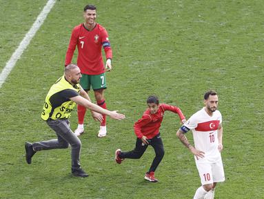 Kemenangan Portugal atas Turki pada laga Euro 2024 diwarnai dengan momen fans menerobos ke dalam lapangan untuk berfoto dengan Cristiano Ronaldo. (AFP/Kenzo Tribouillard)