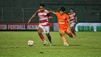 Pemain Madura United, Dodi Alexvan Djin, berusaha mempertahankan penguasaan bola dari sergapan pemain Borneo FC pada leg 1 semifinal Championship Series BRI Liga 1 2023/2024 di Gelora Bangkalan, Madura, Rabu (15/5/2024). (Bola.com/Wahyu Pratama)