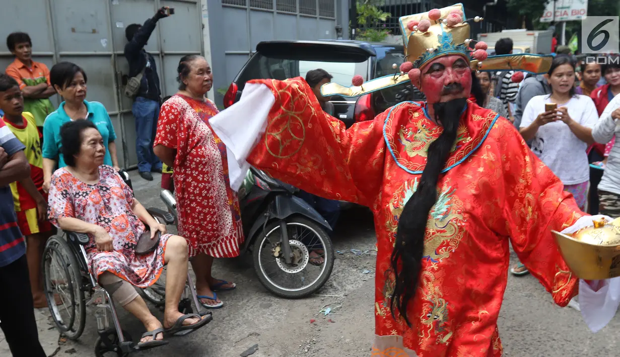 Warga menonton arak-arakan perayaan Cap Go Meh di kawasan Petojo, Jakarta, Selasa (19/2). Arak-arakan ini melewati kawasan Petojo hingga Cideng. (Liputan6.com/Angga Yuniar)