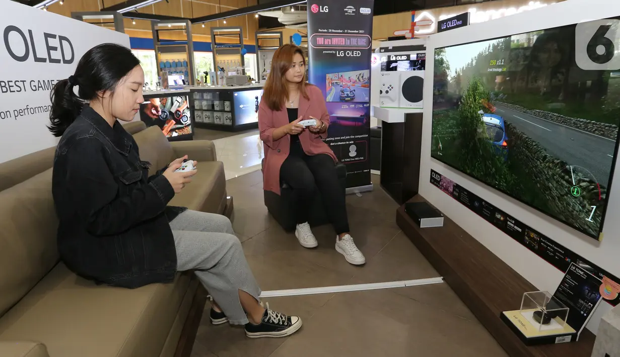 Pengunjung mencoba video game yang ditampilkan layar TV OLED LG di Jakarta, Rabu (12/2021). TV OLED C1 didesain dengan memiliki fitur Game Optimizer memudahkan pengguna mengoptimalkan berbagai pengaturan sesuai kebutuhan gaming. (Liputan6.com)