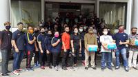 Atlet dan pelatih yang tergabung dalam tim Pelatda PON XX berbagi sembako terhadap warga yang terdampak pandemi COVID-19 di halaman kantor KONI Jawa Barat, Jumat (15/5/2020). (Bola.com/Erwin Snaz)