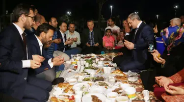 Presiden Turki, Tayyip Erdogan berdoa sebelum berbuka puasa bersama warga di sebuah taman di Istanbul pada Senin (27/5/2019). Buka puasa bersama tersebut dilakukan Erdogan agar lebih dekat dengan warganya. (Murat Kula/Presidential Press Office/Handout via REUTERS)