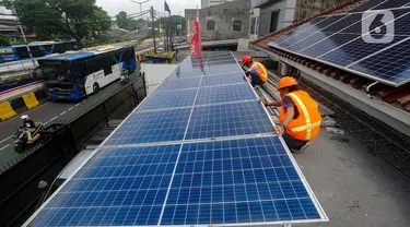 Teknisi Green Energy Nusantara Mandiri memasang PLTS Hybrid 6210 Wp battery 4,8 kwhpada atap rumah kantor di kawasan Manggarai Jakarta, Jumat (29/12/2023). (merdeka.com/Arie Basuki)