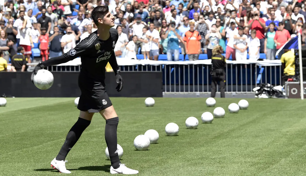 Kiper baru Real Madrid, Thibaut Courtois, melempar bola saat diperkenalkan di Stadion Santiago Bernabeu, Madrid, Kamis (9/8/2018). Pemain berusia 26 tahun pindah setelah empat musim terakhir jadi kiper utama Chelsea. (AFP/Javier Soriano)