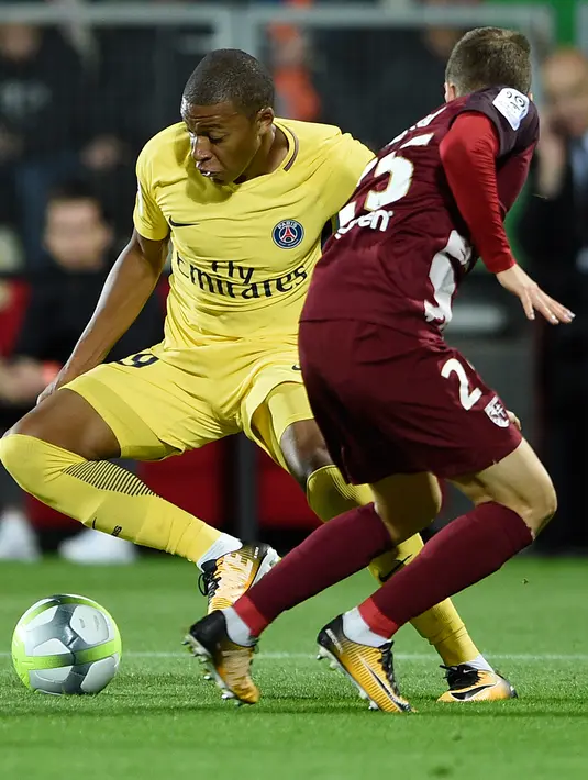 Aksi penyerang PSG, Kylian Mbappe saat berusaha melewati bek Metz, Ivan Balliu pada laga lanjutan Ligue 1 di stadion Longeville-les-Metz, Prancis (8/9). PSG menang 5-1 atas Metz. (AFP Photo/Patrick Hertzog)