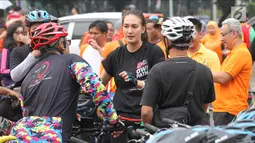 Artis peran Nadine Chandrawinata berbincang dengan rekannya saat mengikuti kampanye gerakan #BebasButaHuruf di kawasan Sudirman, Jakarta, Minggu (13/). Kampanye itu digelar dengan mengadakan kegiatan bersepeda (Liputan6.com/Herman Zakharia)